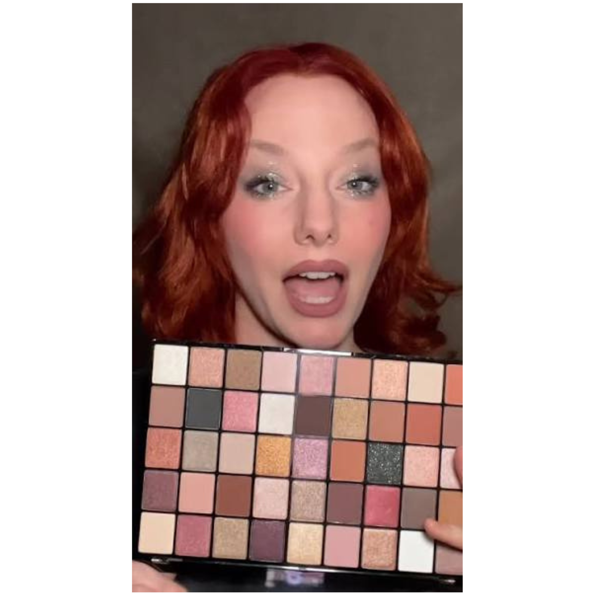 Woman holding Makeup Revolution Maxi Reloaded Large It Up Palette while wearing shimmery eye makeup