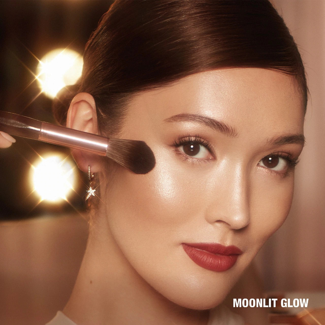 Charlotte Tilbury Glow Glide Face Architect Highlighter in Moonlit Glow with radiant finish on model