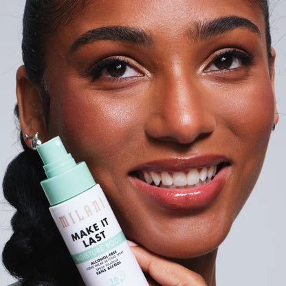 Model holding Milani Make It Last Moisture Boost Setting Spray beside her hydrated makeup look.