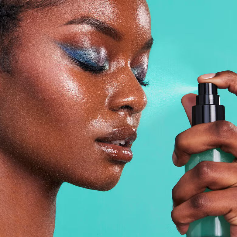 Woman applying e.l.f. Power Grip Dewy Setting Spray for glowing makeup finish