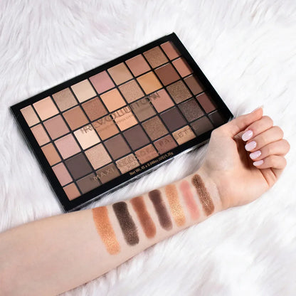 Makeup Revolution Maxi Reloaded Nudes Eyeshadow Palette with neutral shade swatches on an arm